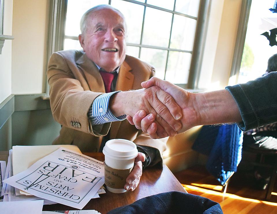 Jim Rogers looks at plans for the upcoming Christmas arts and crafts fair while having coffee at New Boston Bakery.