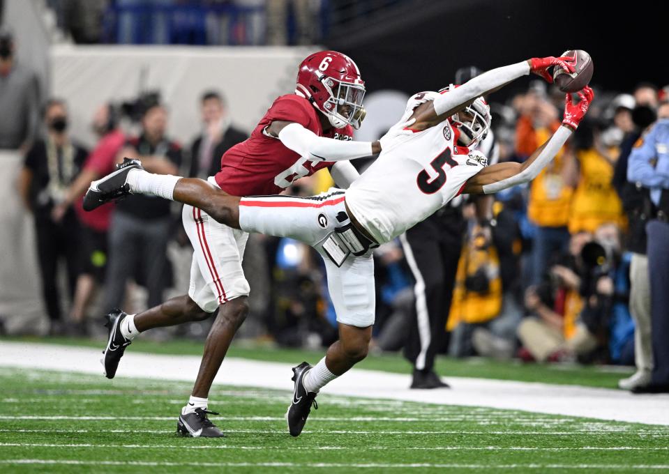 Georgia wide receiver Adonai Mitchell (5) reaches to pull down a catch against Alabama defensive back Khyree Jackson (6) in the second quarter of the College Football Playoff championship game.