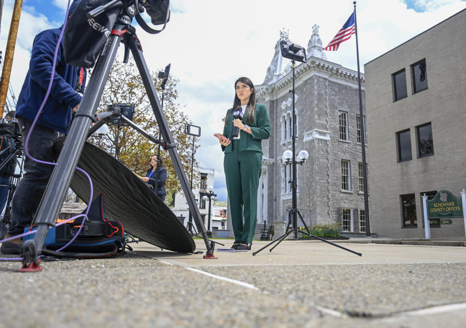 Television reporters produce news reports during Nauman Hussain's new trial in Schoharie, N.Y., on Monday, May 1, 2023. Judge Peter Lynch, rejected a plea agreement for Hussain, who ran the limousine company involved in the 2018 crash that killed 20 people, to avoid prison time. (AP Photo/Hans Pennink)