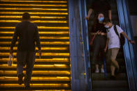 People wearing face masks to protect against the coronavirus ride an escalator at a shopping and office complex in Beijing, Thursday, July 16, 2020. China's economy has rebounded from a painful contraction to grow by 3.2% in the latest quarter compared to a year ago. The expansion came as anti-virus lockdowns were lifted and factories and stores reopened. (AP Photo/Mark Schiefelbein)