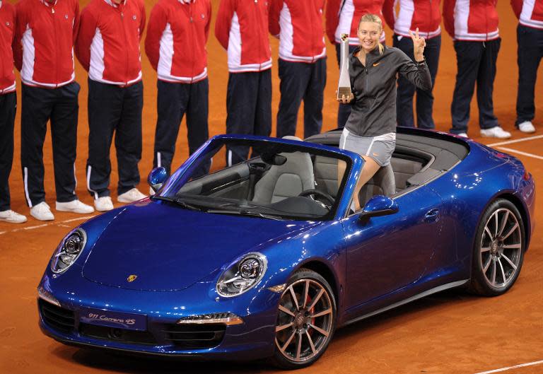 Maria Sharapova holds her trophy in the winner's prize, a Porsche 911 Carrera 4 S Cabriolet, after defeating China's Li Na in the final of the WTA Porsche Tennis Grand Prix in Stuttgart, southwestern Germany, on April 28, 2013