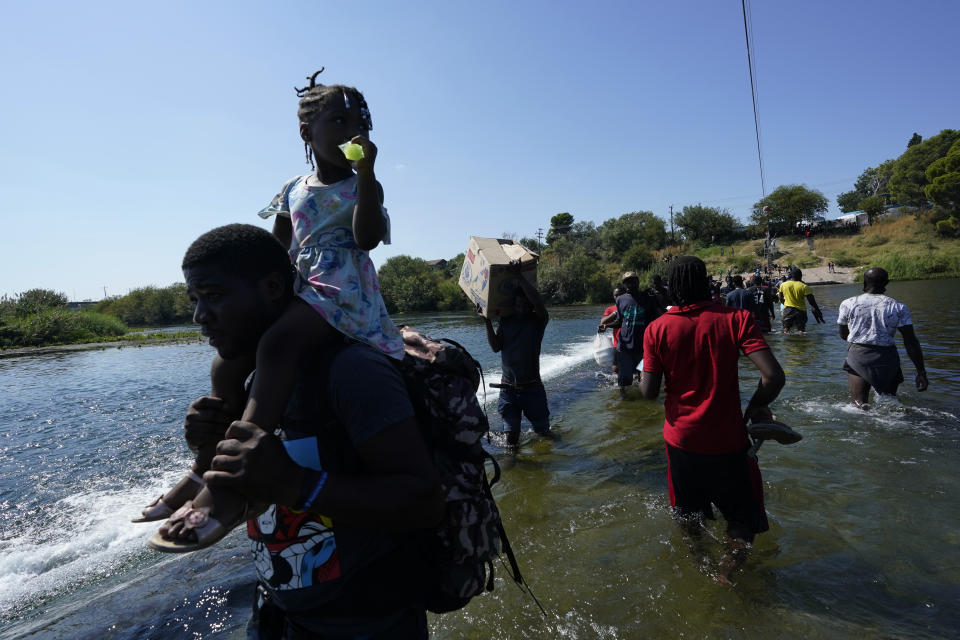 Haitian migrants use a dam to cross to and from the United States from Mexico, Friday, Sept. 17, 2021, in Del Rio, Texas. Thousands of Haitian migrants have assembled under and around a bridge in Del Rio presenting the Biden administration with a fresh and immediate challenge as it tries to manage large numbers of asylum-seekers who have been reaching U.S. soil. (AP Photo/Eric Gay)