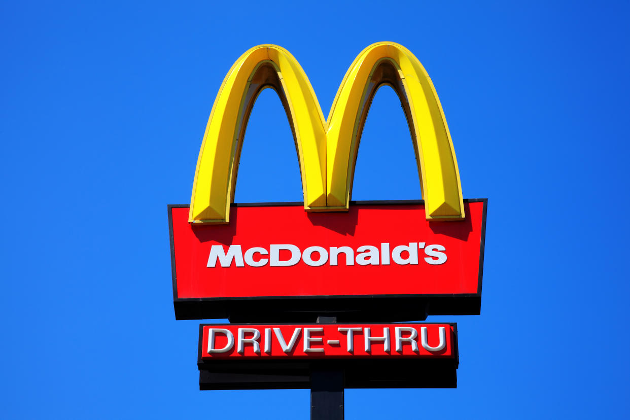 London, United Kingdom, May 27, 2012 : McDonald's yellow and red drive-thru logo advertising sign placed on a pole with a clear blue sky