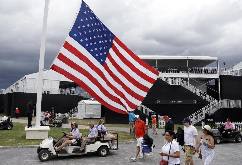 An American flag is lowered from a flag pole after play was suspended due to approaching inclement weather during the first round of the Cadillac Championship golf tournament, Thursday, March 6, 2014, in Doral, Fla. (AP Photo/Lynne Sladky)