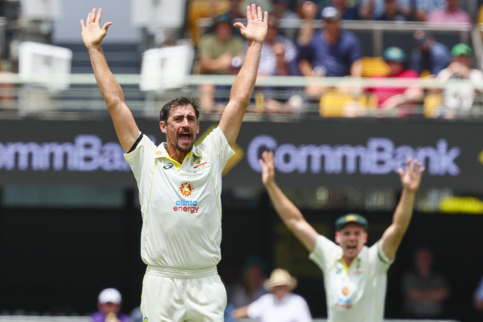 Australia's Mitchell Starc, left, appeals successfully for the wicket of South Africa's Dean Elgar during the first cricket test between South Africa and Australia at the Gabba in Brisbane, Australia, Saturday, Dec. 17, 2022. (AP Photo/Tertius Pickard)