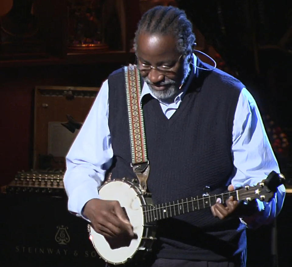 John Francis tocando su banjo al inicio de su charla en TE