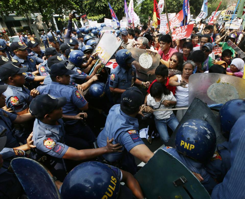 Policemen and protesters clash as the latter try to force their way closer to the U.S. Embassy for a rally against next week's visit of U.S. President Barack Obama Wednesday, April 23, 2014 in Manila, Philippines. Philippine police armed with truncheon, shields and water hose have clashed with more than 100 left-wing activists who rallied at the U.S. Embassy in Manila to oppose a visit by Obama and a looming pact that will increase the American military presence in the Philippines. (AP Photo/Bullit Marquez)