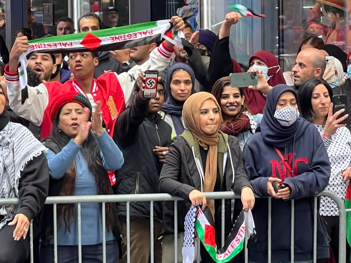 A pro-Palestinian demonstrator holes up a Swastika on their phone at a rally in Times Square (Stuart Meissner)