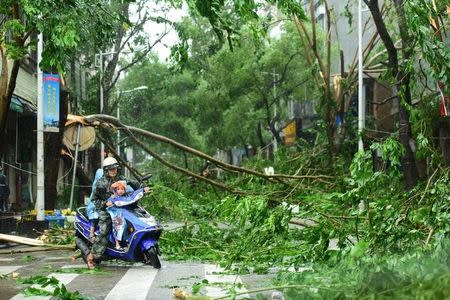 Residents ride at a street as Typhoon Sarika lands in Qionghai, Hainan Province, China, October 18, 2016. REUTERS/Stringer