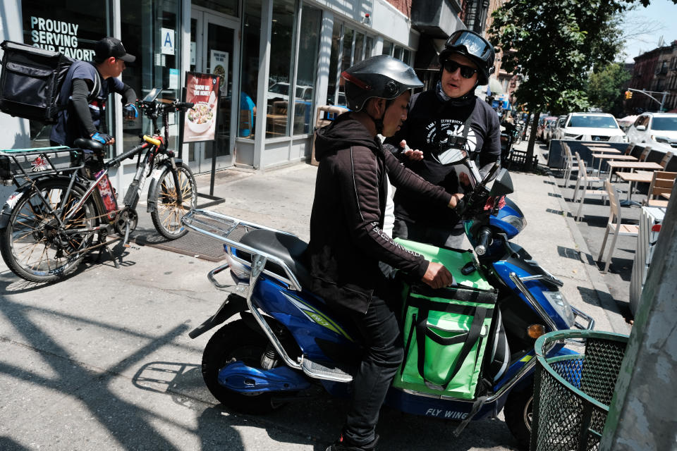 William, un organizador del Proyecto de Justicia Laboral, habla con los repartidores afuera de un restaurante que utiliza entregas de aplicaciones el 7 de julio de 2023 en la ciudad de Nueva York. Uber Eats, DoorDash y GrubHub están demandando a la ciudad de Nueva York en un intento de bloquear una nueva ley que establecería requisitos de salario mínimo para los repartidores. La mayoría de los trabajadores de entrega de aplicaciones actualmente dependen de las propinas de los clientes para obtener el 95% de su salario. (Foto de Spencer Platt/Getty Images)