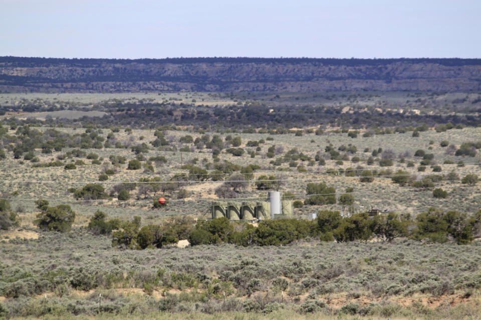 A well site stands across a highway from a school in Counselor, N.M., on May 17, 2023. On Thursday, June 1, 2023, New Mexico Land Commissioner Stephanie Garcia Richard issued an executive order that includes a ban on all new oil and gas leases on state trust land within a mile of schools or other educational institutions, including day care centers, preschools and sports facilities that students use. (AP Photo/Susan Montoya Bryan)
