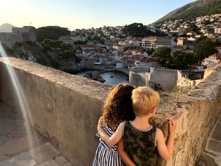 two children hugging overlooking a scenic view.