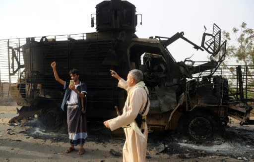 Yemenis check the wreckage of an armoured vehicle after clashes near the coastal town of Hodeida, on May 29, 2018