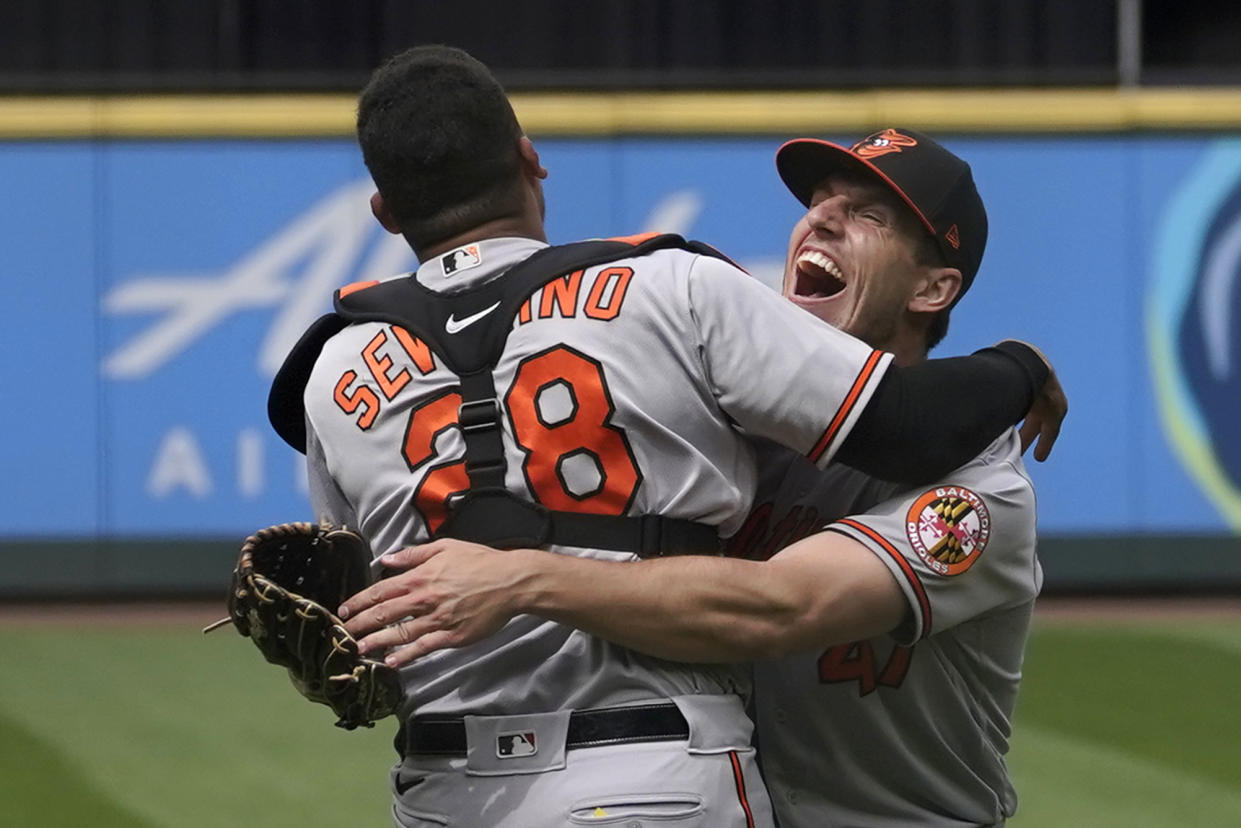 Baltimore Orioles starting pitcher John Means, right, hugs catcher Pedro Severino 