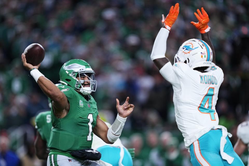 Philadelphia Eagles quarterback Jalen Hurts (1) looks to throw under pressure from Miami Dolphins cornerback Kader Kohou (4) during the second half of an NFL football game Sunday, Oct. 22, 2023, in Philadelphia. (AP Photo/Matt Rourke)