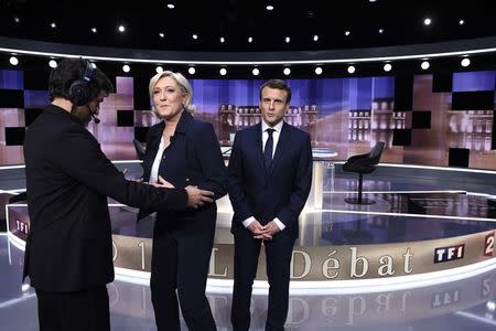 Candidates for the 2017 presidential election, Emmanuel Macron (R), head of the political movement En Marche !, or Onwards !, and Marine Le Pen, of the French National Front (FN) party, pose prior to the start of a live prime-time debate in the studios of French television station France 2, and French private station TF1 in La Plaine-Saint-Denis, near Paris, France, May 3, 2017. REUTERS/Eric Feferberg/Pool