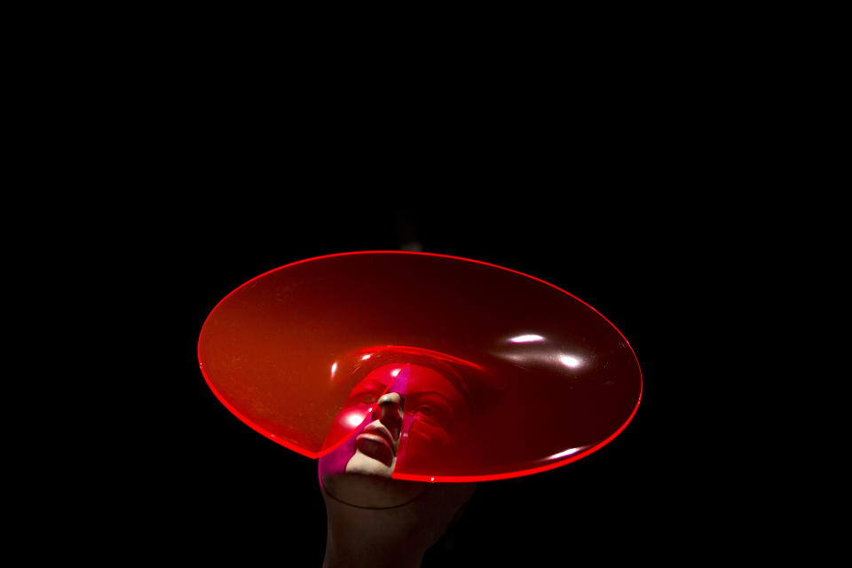 A Philip Treacy plexiglas circular hat with slit detail is displayed at the press view of the "Isabella Blow: Fashion Galore!" exhibition in London, Tuesday, Nov. 19, 2013. The exhibition, which runs from November 20 to March 2, celebrates the life and wardrobe of the late British patron of fashion and art who discovered many young fashion design talents. (AP Photo/Matt Dunham)