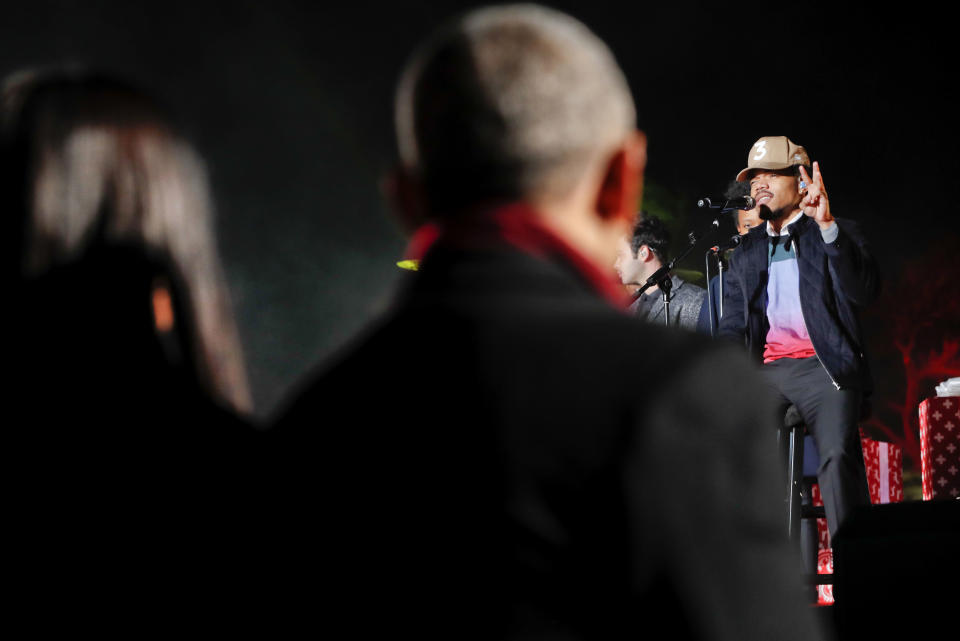 FILE - In this Dec. 1, 2016, file photo, President Barack Obama, center, and first lady Michelle Obama, left, listen to Chancelor Bennett, "Chance the Rapper", right, from Chicago, perform at the lighting the 2016 National Christmas Tree ceremony at the Ellipse near the White House in Washington. The rapper tweeted a photo of himself on Feb. 2, 2017, wearing Obama-themed clothing. (AP Photo/Pablo Martinez Monsivais, File)