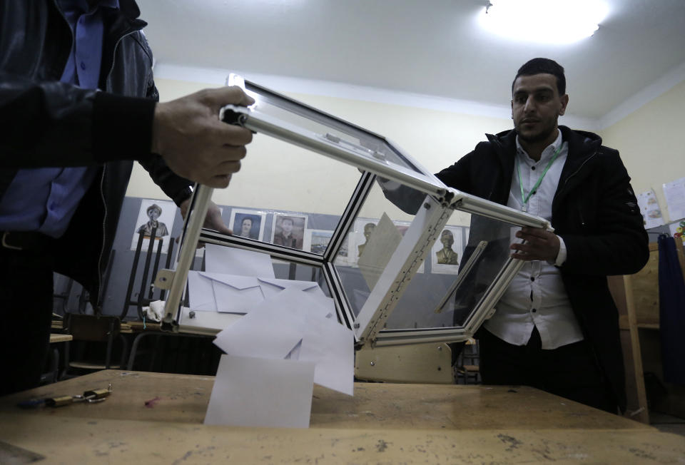 Polling station workers empty a ballot box in a polling station Thursday Dec.12, 2019 in Algiers. Algerians — without a leader since April — voted for a new president or boycotted and held street protests against the elections decried by a massive pro-democracy movement that forced former leader Abdelaziz Bouteflika to resign. (AP Photo/Toufik Doudou)