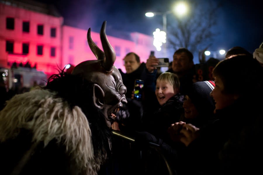 A participant wearing a traditional Krampus costume and a mask performs during a Krampus run in Hollabrunn, Austria, Sunday, Nov. 26, 2022. (AP Photo/Michael Gruber)