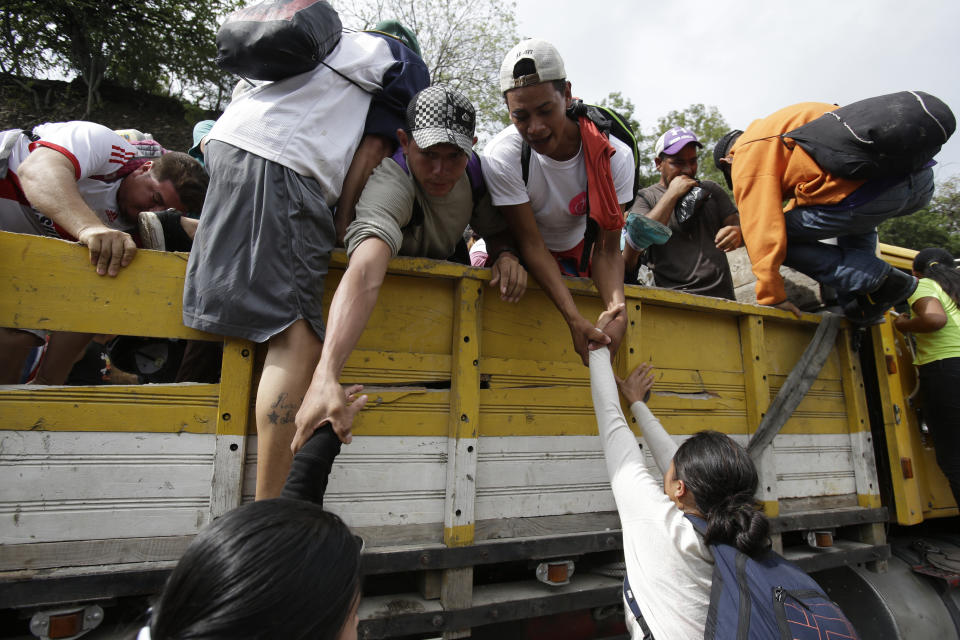 Honduran migrants bound to the U.S border climb into the bed of a truck in Zacapa, Guatemala, Wednesday, Oct. 17, 2018. The group of some 2,000 Honduran migrants hit the road in Guatemala again Wednesday, hoping to reach the United States despite President Donald Trump's threat to cut off aid to Central American countries that don't stop them. (AP Photo/Moises Castillo)