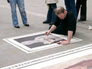 Artist painting on the floor in public