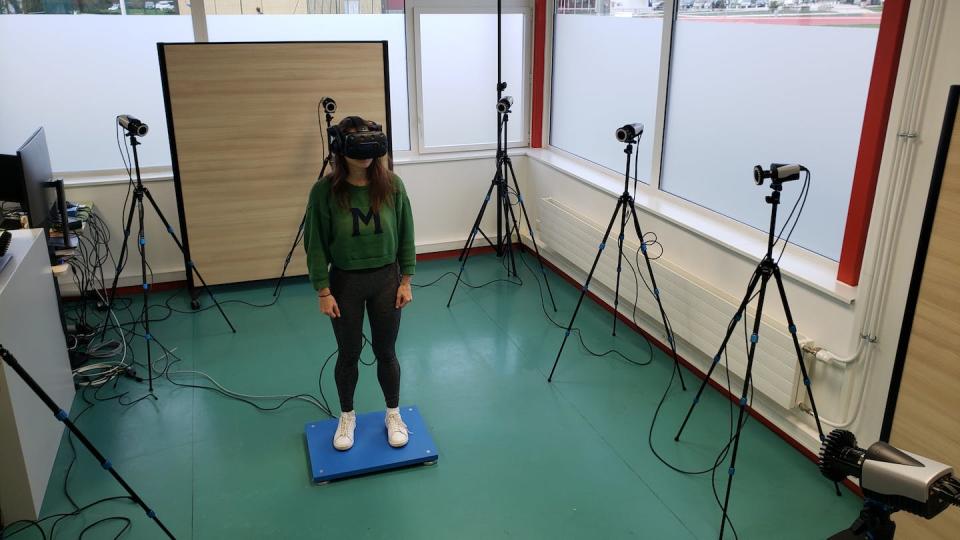 Une utilisatrice de VR teste un système qui simule le vide sous ses pieds pour lutter contre le vertige. Fourni par l'auteur