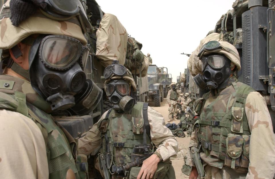 U.S. Marines from the 2nd Battalion, 8th Marines wear their gas masks on March 21, 2003 as they prepare to advance towards Iraq.