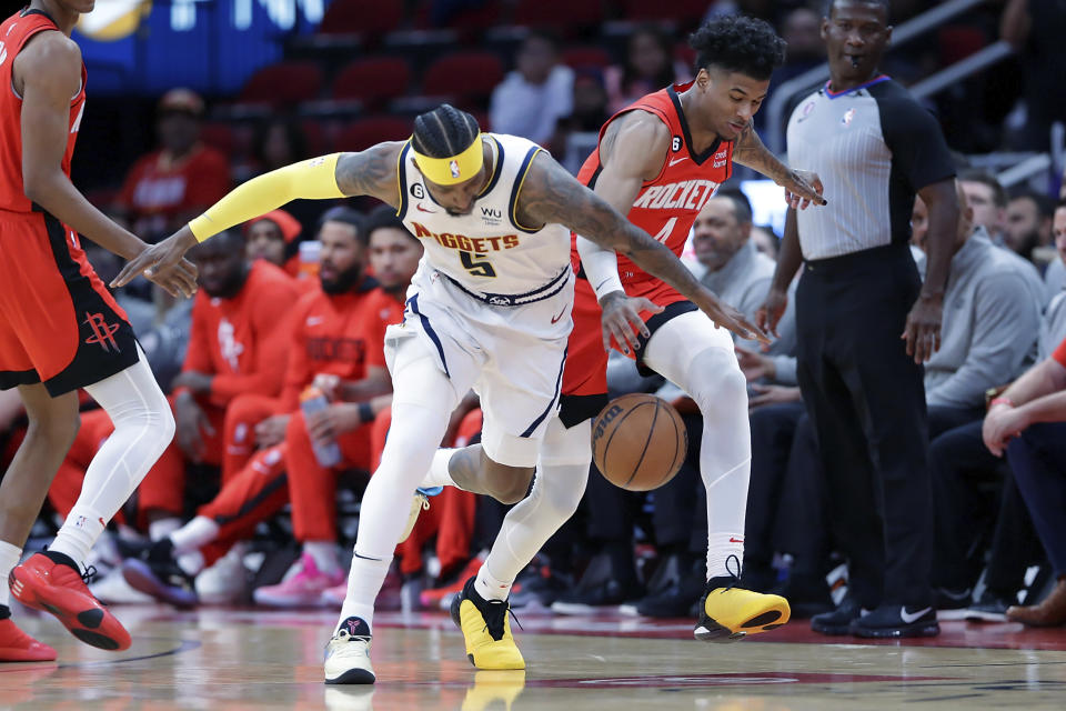 Houston Rockets guard Jalen Green, right, attempts to steal the ball from Denver Nuggets guard Kentavious Caldwell-Pope (5) during the first half of an NBA basketball game, Tuesday, April 4, 2023, in Houston. (AP Photo/Michael Wyke)