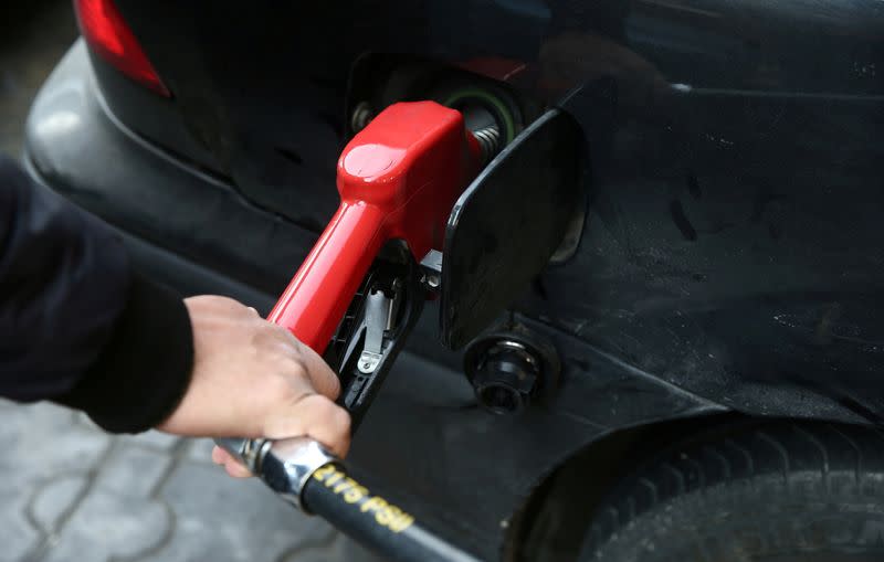 FILE PHOTO: A man fills up his car's tank at a petrol station, after fuel price increased in Tehran