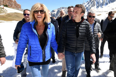 Emmanuel Macron (R), head of the political movement En Marche ! (Onwards !) and candidate for the 2017 presidential election, and his wife Brigitte Trogneux arrive for a lunch break at the mountain top during a campaign visit in Bagneres de Bigorre, in the Pyrenees mountain, France, April 12, 2017. REUTERS/Eric Feferberg/Pool