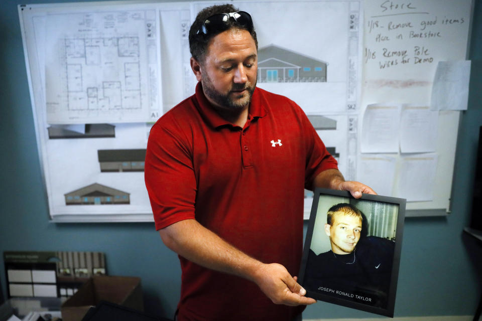 Justin Oyer, executive director at Warriors 4 Christ, an addiction recovery center and program, holds an image of his cousin Joseph Ronald Taylor, who died from opioid addiction, Wednesday, July 17, 2019, in Jackson, Ohio. Newly released prescription opioid statistics underscore how widespread pill use has been in towns and small cities of America’s Appalachian region. In Jackson County, an average yearly total of 107 opioid pills for every resident were distributed over a seven-year period. (AP Photo/John Minchillo)