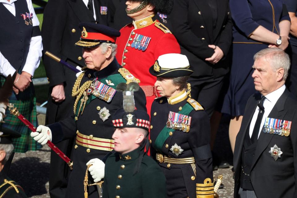 TOPSHOT - Britain's King Charles III (L), Britain's Princess Anne, Princess Royal (C), and Britain's Prince Andrew, Duke of York walk behind the procession of Queen Elizabeth II's coffin, from the Palace of Holyroodhouse to St Giles Cathedral, on the Royal Mile on September 12, 2022, where Queen Elizabeth II will lie at rest. - Mourners will on Monday get the first opportunity to pay respects before the coffin of Queen Elizabeth II, as it lies in an Edinburgh cathedral where King Charles III will preside over a vigil. (Photo by PHIL NOBLE / POOL / AFP) (Photo by PHIL NOBLE/POOL/AFP via Getty Images)