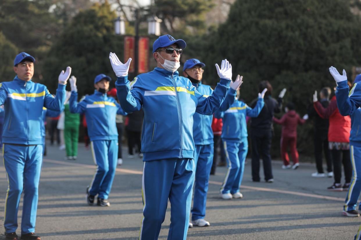 This photo taken on April 6, 2020, shows residents wearing face masks while dancing at a park in Shenyang in China's northeastern Liaoning province.