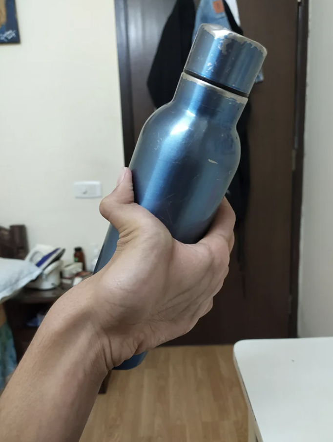 A hand gripping a bottle backwards