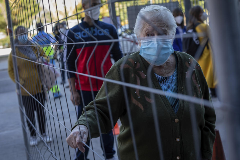 An elderly woman lines up for a rapid antigen test for COVID-19 in the southern neighbourhood of Vallecas in Madrid, Spain, Tuesday, Sept. 29, 2020. Madrid has a rate of infection 2.5 times higher than the national average, which is already three times the European average, including the UK. (AP Photo/Bernat Armangue)