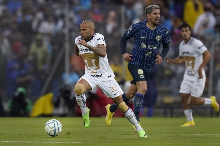 El brasileño Dani Alves, de los Pumas, conduce el balón junto a Diego Valdés, del América, en un encuentro de la Liga MX, disputado el sábado 13 de agosto de 2022 (AP Foto/Eduardo Verdugo)