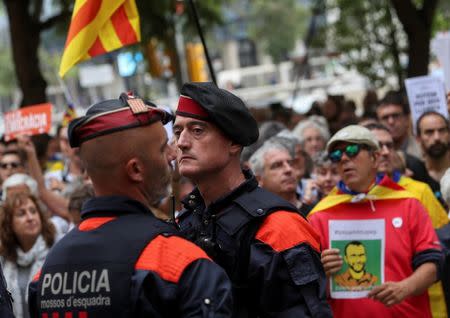 Catalan regional police officers stand in front of protesters who gathered in support of Catalan officials arrested in raids on government offices, outside a courthouse in Barcelona, Spain September 22, 2017. REUTERS/Susana Vera