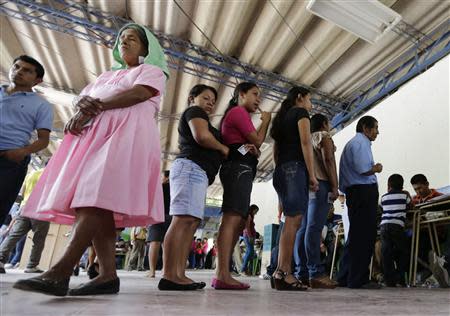 Voters wait in line to cast their vote in a presidential election runoff at a polling station outside in San Salvador March 9, 2014. REUTERS/Henry Romero