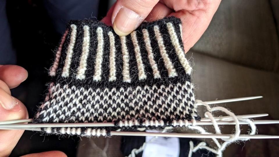 Knitting the gloves on four needles creates a seamless effect