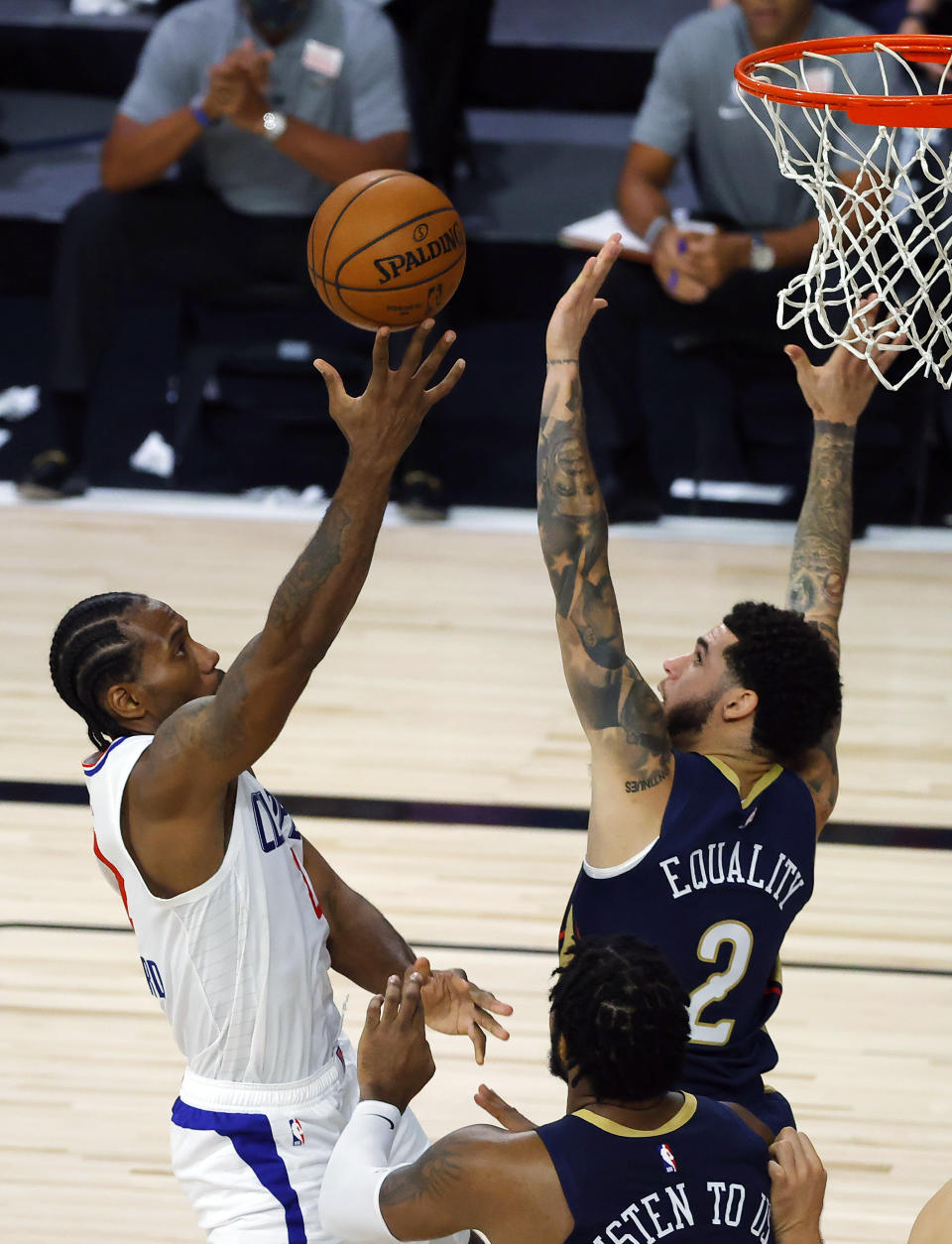 Los Angeles Clippers' Kawhi Leonard, left, goes up against New Orleans Pelicans' Lonzo Ball, top right, during an NBA basketball game Saturday, Aug. 1, 2020, in Lake Buena Vista, Fla. (Kevin C. Cox/Pool Photo via AP)