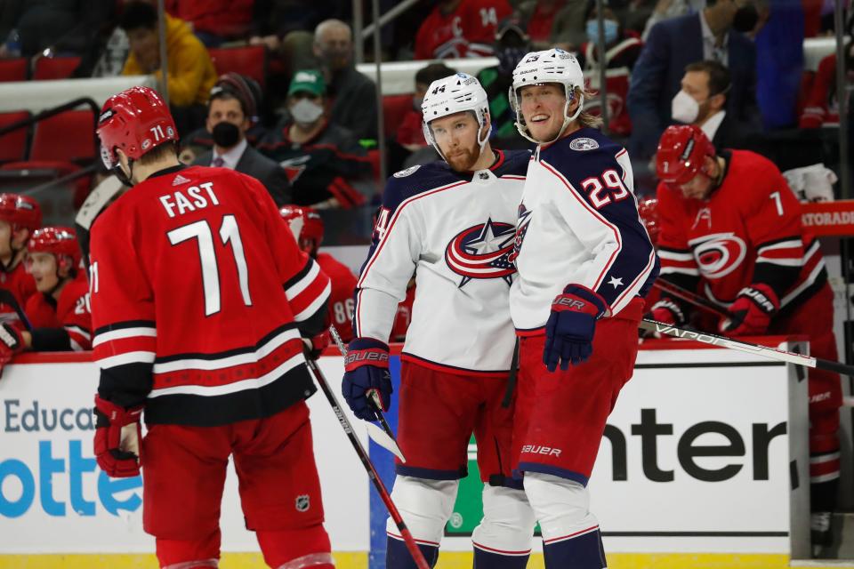 Columbus Blue Jackets' Patrik Laine (29) celebrates his goal with teammate Vladislav Gavrikov (44) as Carolina Hurricanes' Jesper Fast (71) skates by during the third period of an NHL hockey game in Raleigh, N.C., Thursday, Jan. 13, 2022. (AP Photo/Karl B DeBlaker)