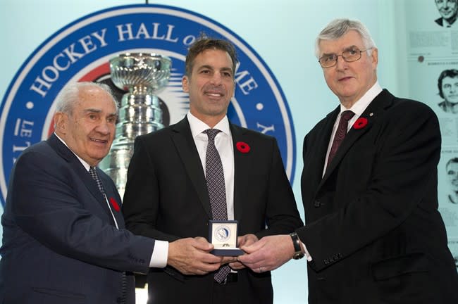 Hockey Hall of Fame inductee Chris Chelios is presented with his ring by Chairman Pat Quinn (right) and Chair of the selection committee Jim Gregory at the Hall in Toronto on Friday November 8, 2013. THE CANADIAN PRESS/Frank Gunn