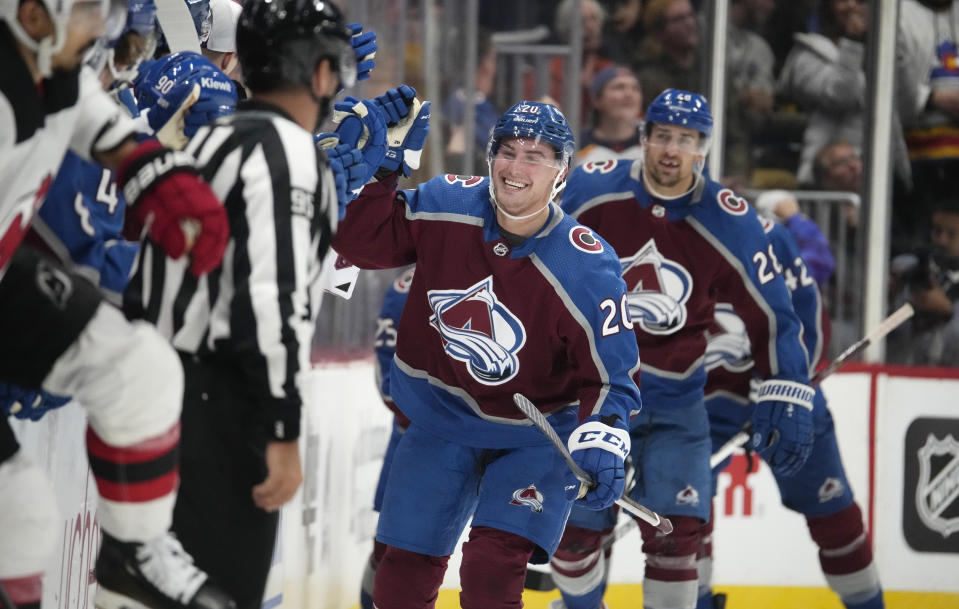 Colorado Avalanche center Ross Colton (20) is congratulated as he passes the team box after scoring a goal in the second period of an NHL hockey game against the New Jersey Devils on Tuesday, Nov. 7, 2023, in Denver. (AP Photo/David Zalubowski)