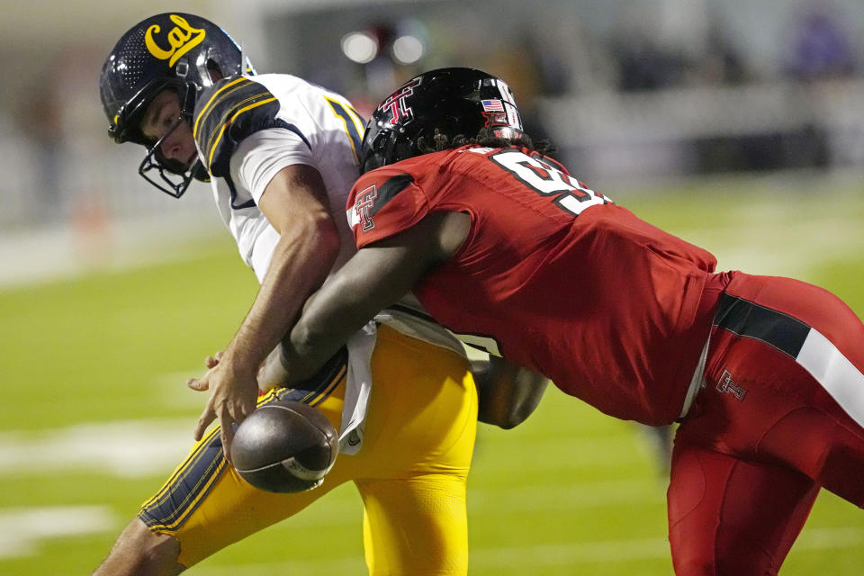 California quarterback Fernando Mendoza (15) looks back toward the ball after having it stripped by Texas Tech defensive lineman Amier Washington (96) during the first half of the Independence Bowl NCAA college football game Saturday, Dec. 16, 2023, in Shreveport, La. (AP Photo/Rogelio V. Solis)