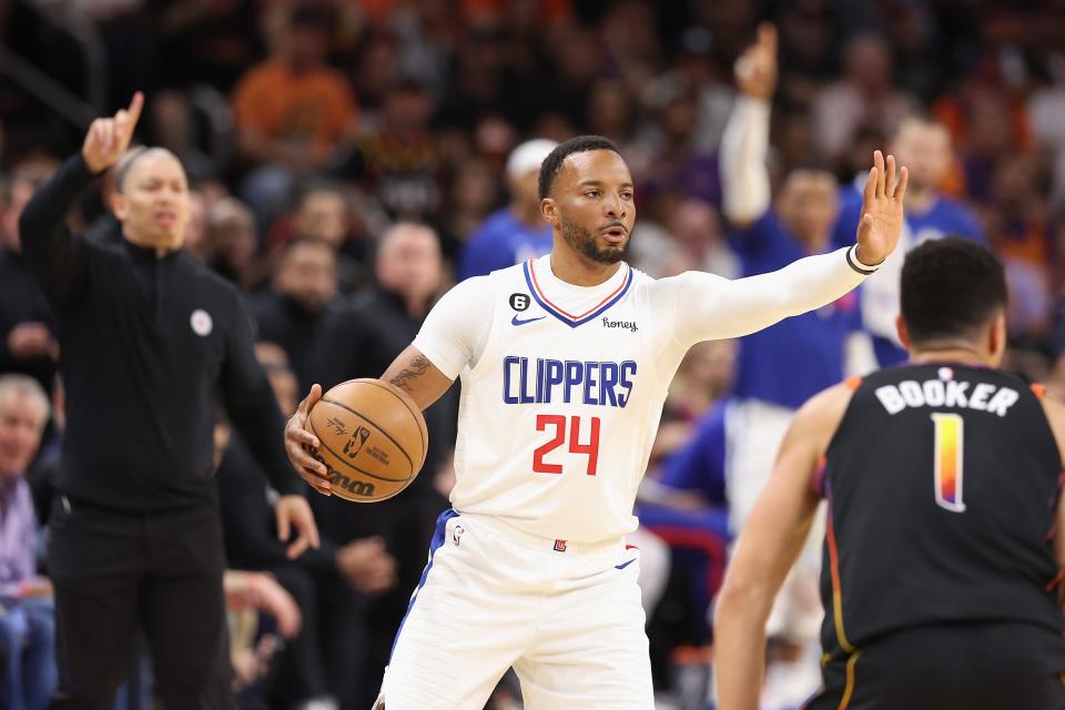 Norman Powell #24 of the LA Clippers handles the ball against Devin Booker #1 of the Phoenix Suns during the first half of Game 1 of the Western Conference First Round Playoffs at Footprint Center on April 16, 2023, in Phoenix, Arizona.