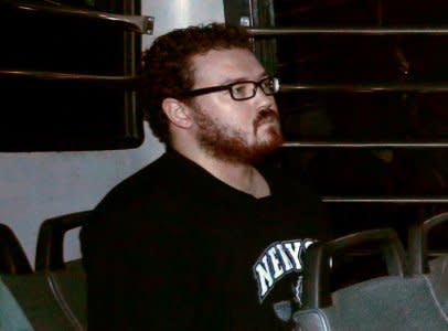 FILE PHOTO: Rurik George Caton Jutting, a British banker charged with two counts of murder after police found the bodies of two women in his apartment, sitting in the back row of a prison bus as he arrives at the Eastern Law Courts in Hong Kong November 24, 2014. REUTERS/Bobby Yip/File Photo