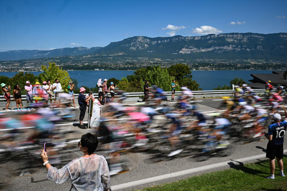 The pack of riders cycles past the Lac du Bourget during the 18th stage of the 110th edition of the Tour de France cycling race, 184 km between Moutiers and Bourg-en-Bresse, in the French Alps, on July 20, 2023. (Photo by Marco BERTORELLO / AFP)