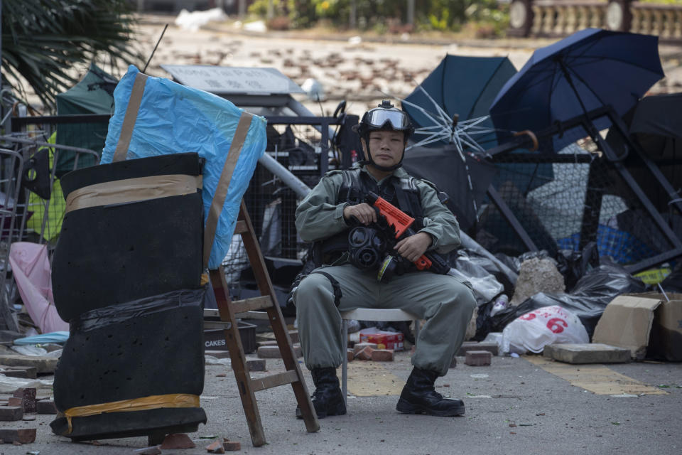 A police officer watches the Polytechnic University entrance in Hong Kong on Wednesday, Nov. 20, 2019. A small group of protesters refused to leave Hong Kong Polytechnic University, the remnants of hundreds who took over the campus for several days. They won't leave because they would face arrest. Police have set up a cordon around the area to prevent anyone from escaping. (AP Photo/Ng Han Guan)