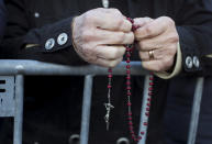 A woman prays as they wait for Pope Francis to arrive to celebrate a Mass in Confluence Park in Kaunas, Lithuania, Sunday, Sept. 23, 2018. Pope Francis is on the second of his two-day visit to Lithuania. (AP Photo/Mindaugas Kulbis)